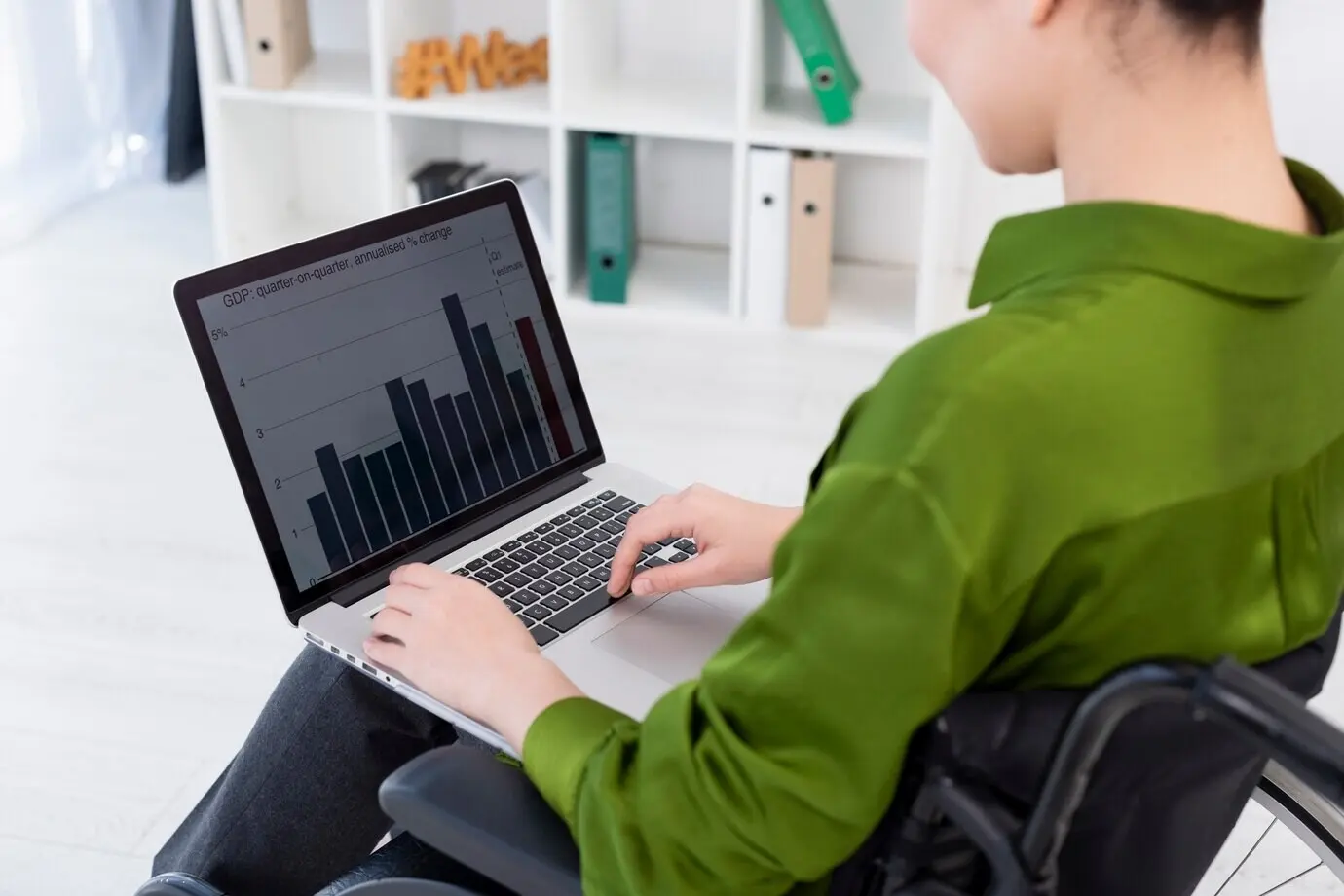 Крупный план женщины, работающей за ноутбуком.